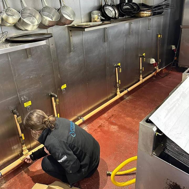 A Forshaw engineer connecting gas pipework to a commercial kitchen range