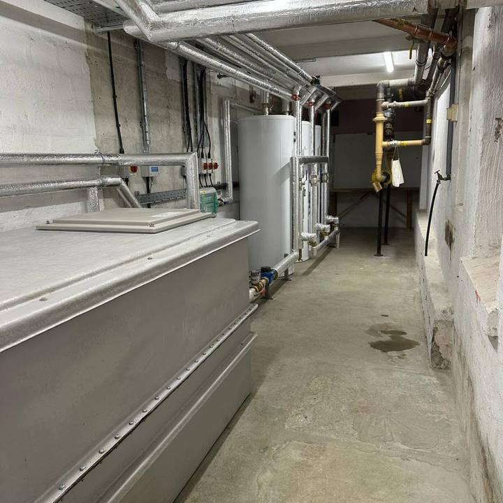 A plant room corridor with tanks, cylinders and pipework
